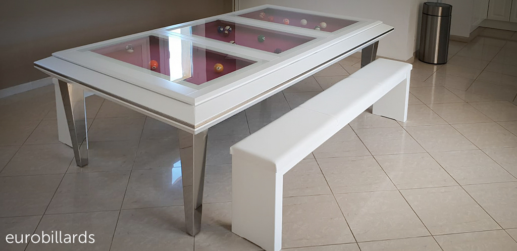 table transformable en billard QUARTZ modele 210 en jeu américain au tissu fushia visible à travers les verres du plateau. Les deux bancs Tendance blanc avec assise en simili cuir accueillent facilement 6 convives
